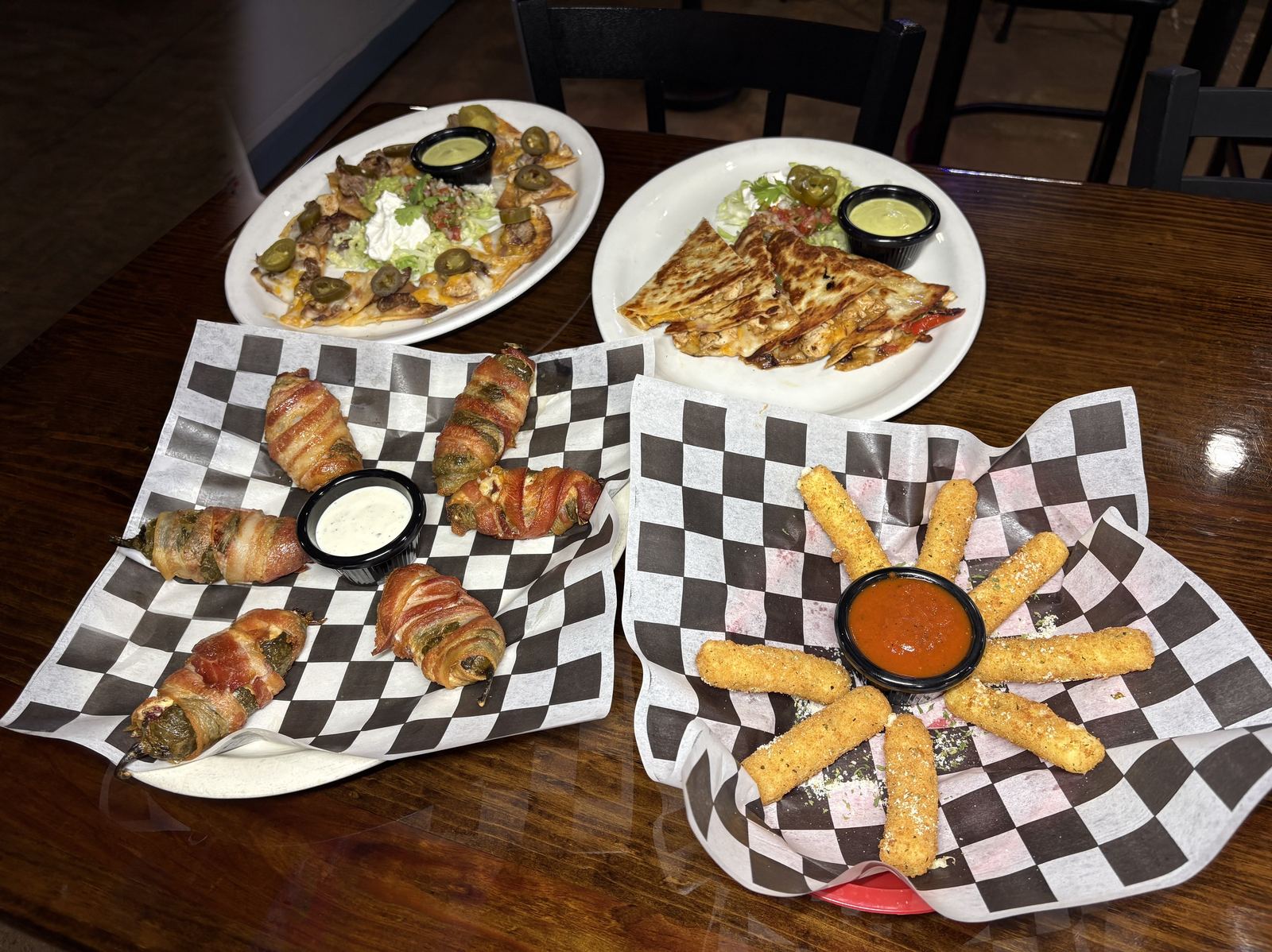 Appetizer spread — poppers, mozzarella sticks, nachos and quesadillas