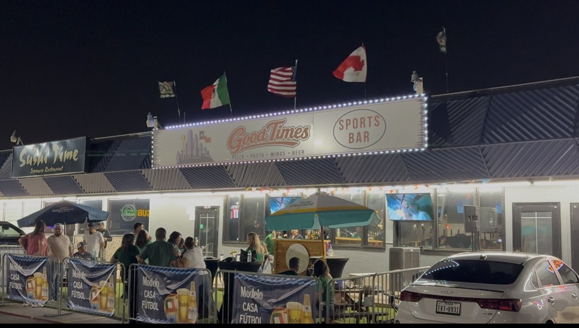 Good Times Sports Bar marquee at night with Mexico, USA, and Canada flags